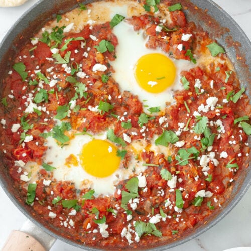 Shakshuka in a frying pan with tomatoes and eggs.