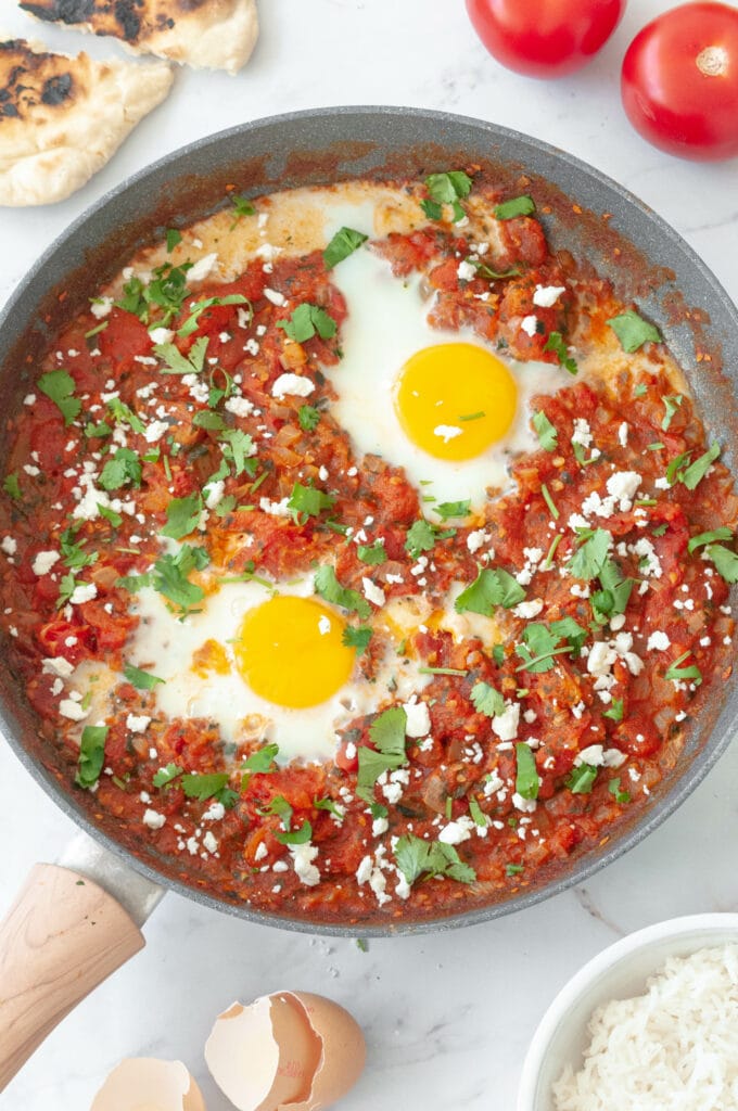 Shakshuka in a frying pan with tomatoes and eggs.
