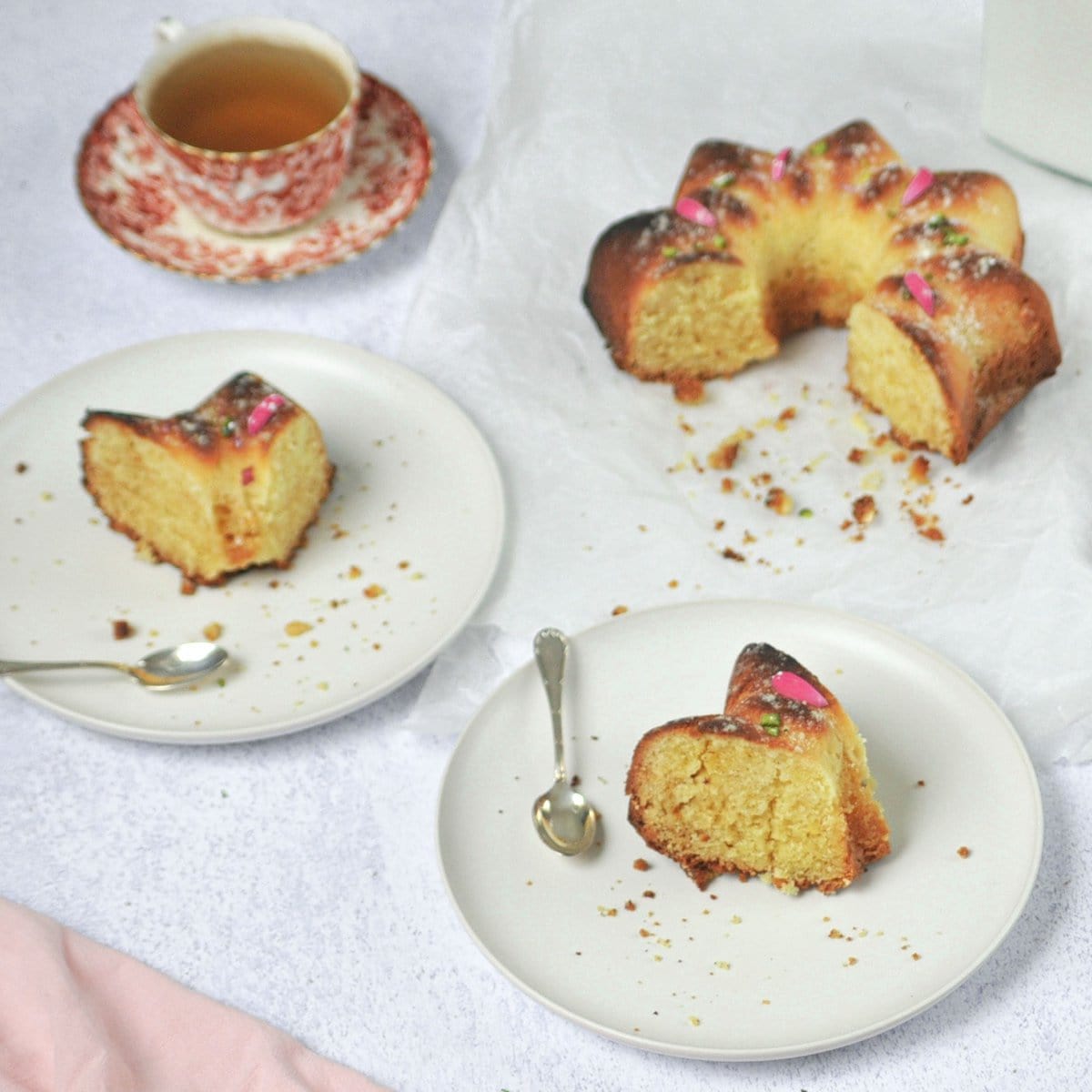 Pieces of pound cake on plates with cake and a cup of tea.