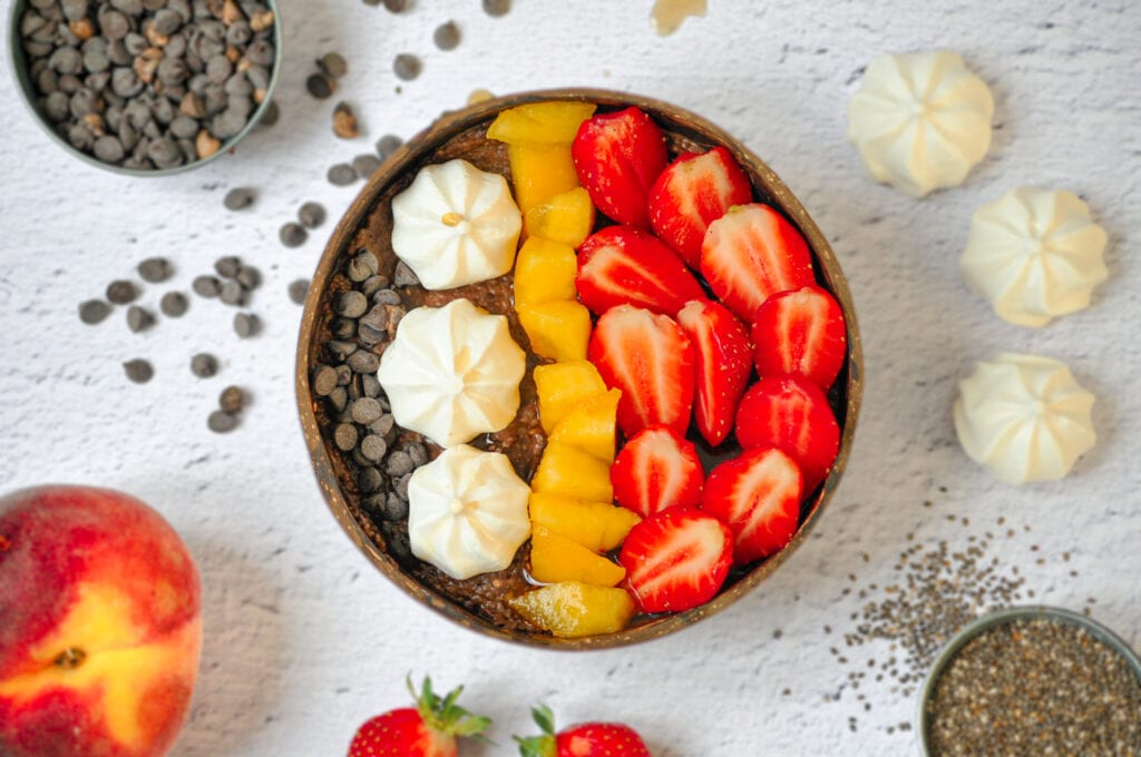 Chocolate chia pudding with meringues, peaches, strawberries and chocolate chips.