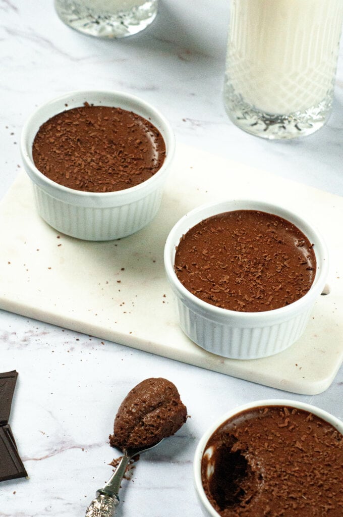 3 mousses au chocolat dont une entamée avec une cuillère.
