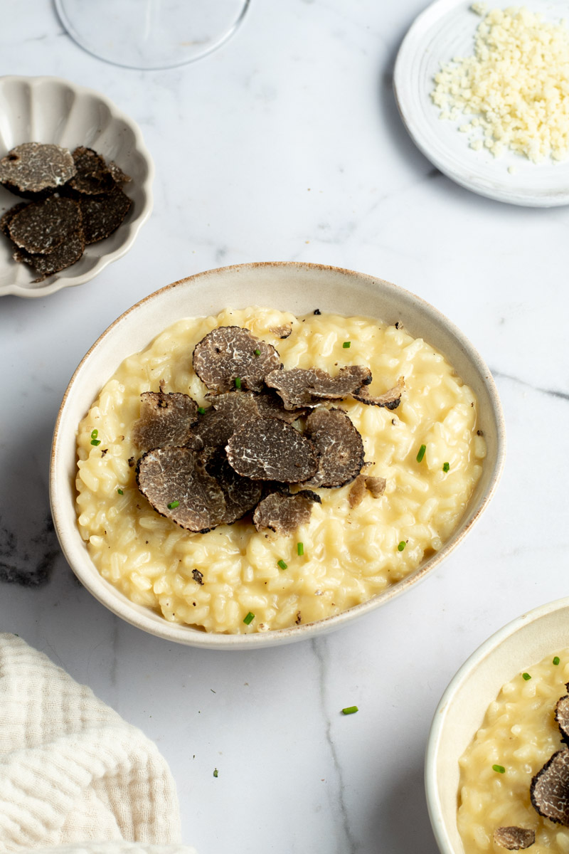 Black truffle risotto in a beige bowl.