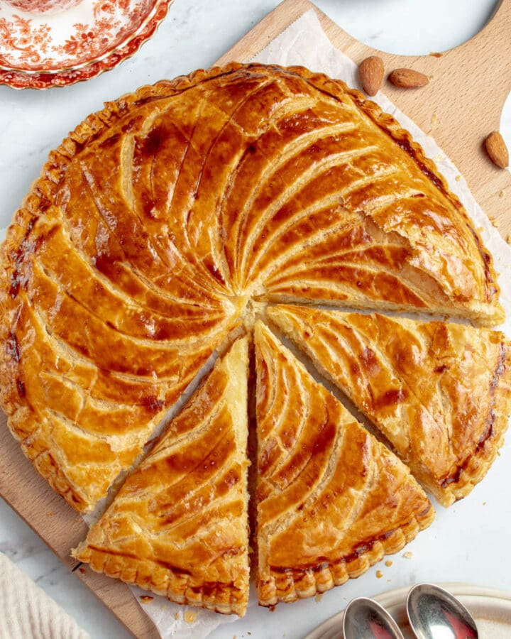 Galette des Rois coupée en parts, sur une planche.