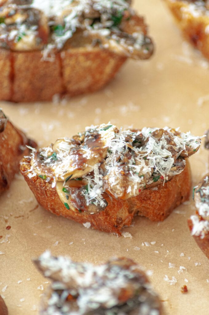Crostini à l'ail recouvert de champignons grillés et de Parmesan râpé.