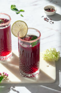 Deux cocktails à l'hibiscus rouge dans deux verres.