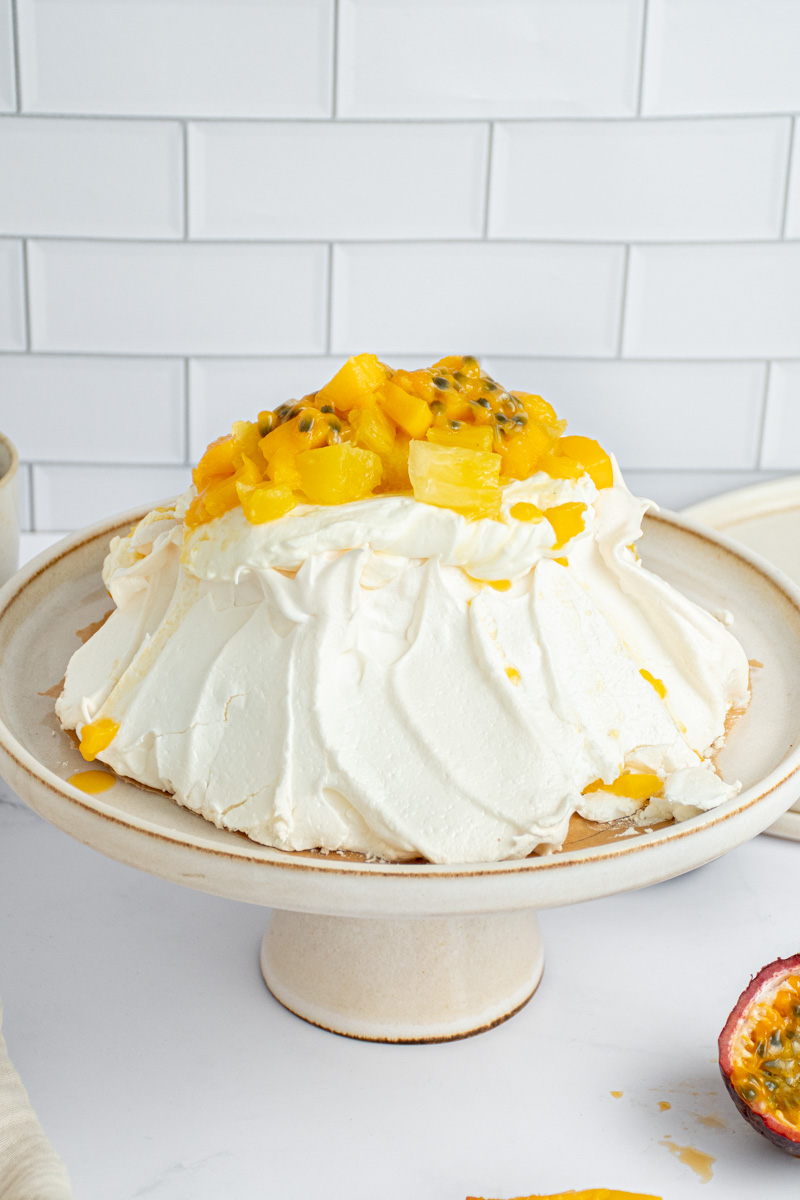 Pavlova with exotic fruits in a cake tin.