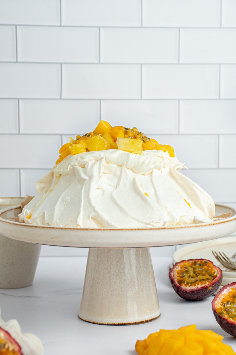 Pavlova with exotic fruits in a cake tin.