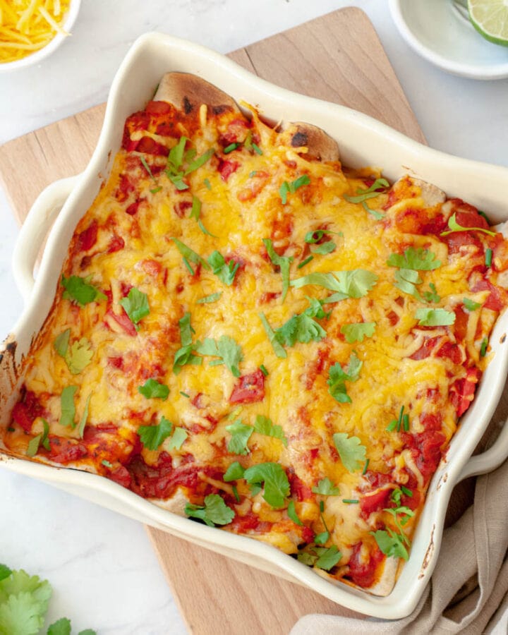 Plat carré d'enchiladas sur une planche en bois.