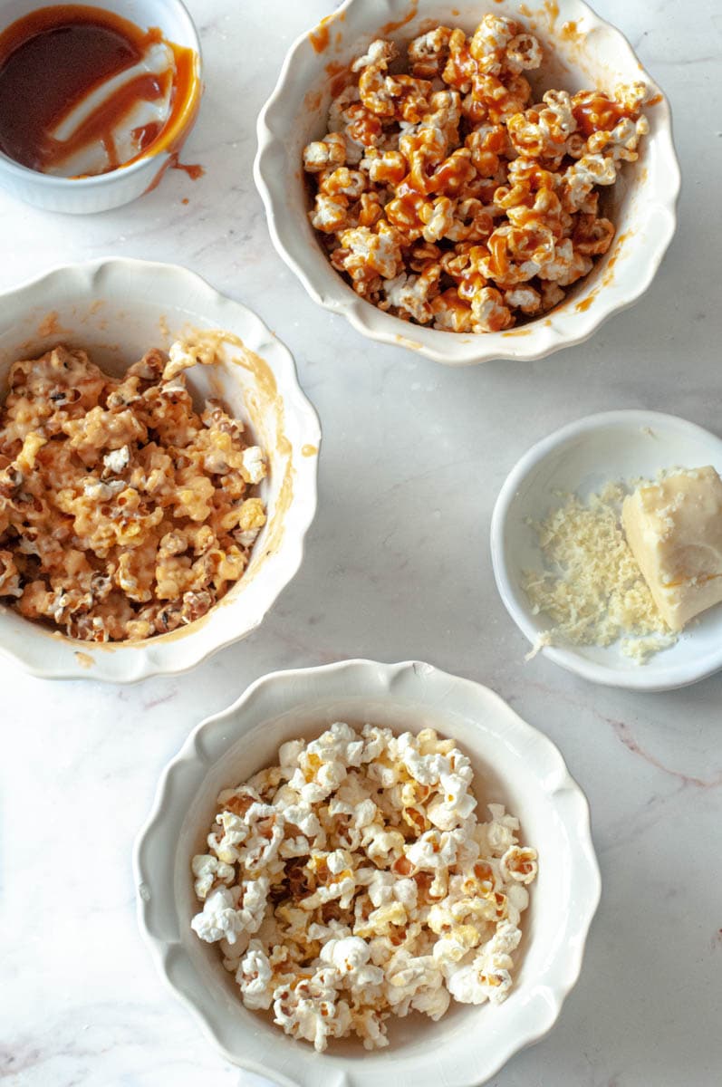 3 bowls of popcorn with a small bowl of caramel and another of cheddar.