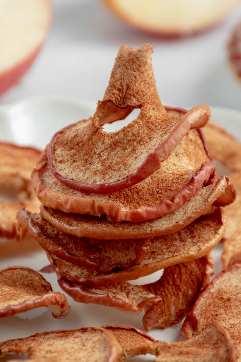 Apple chips stacked on top of each other on a plate.