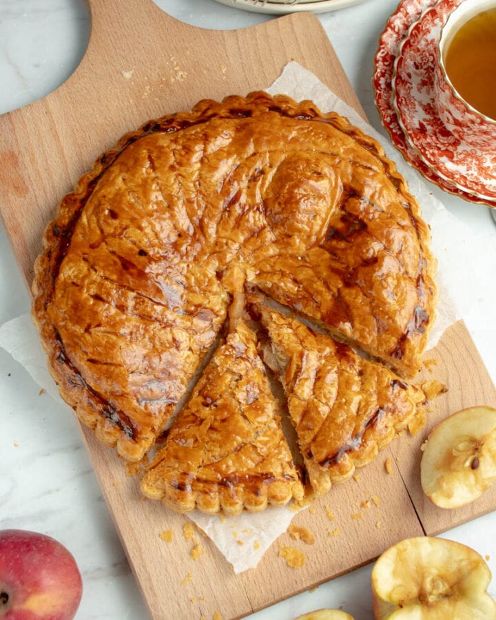 Galette des Rois aux pommes sur une planche avec une tasse de thé.