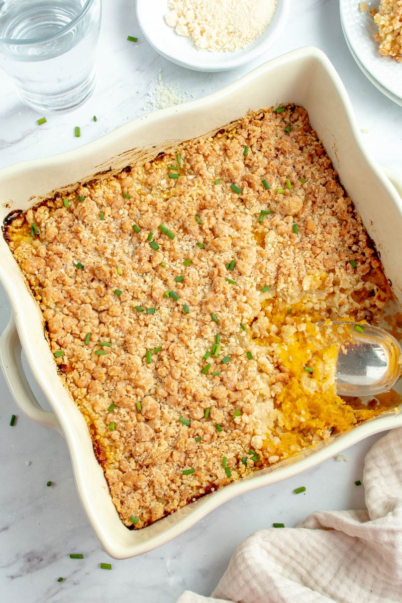 Butternut crumble in a dish with a spoon that takes a slice.