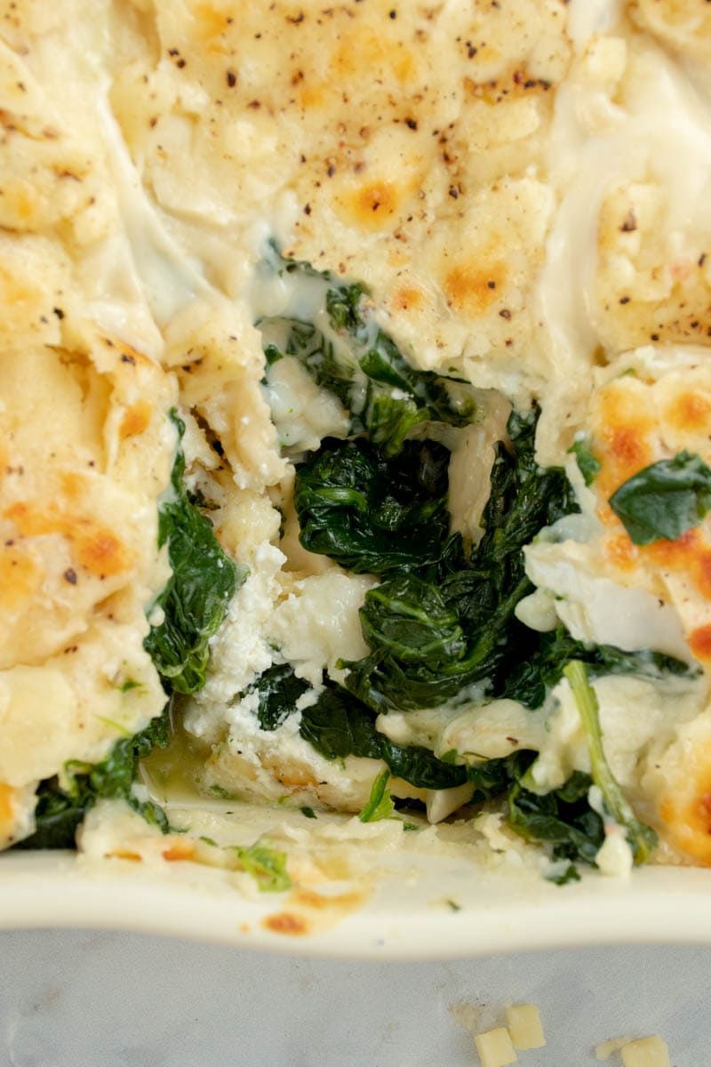 Spinach and goat cheese lasagne in a square dish.