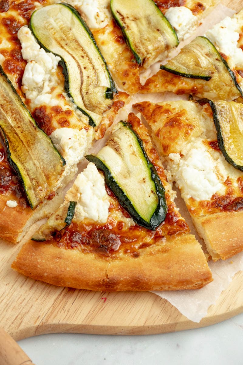 Slice of honey-goat pizza with grilled zucchini slices.