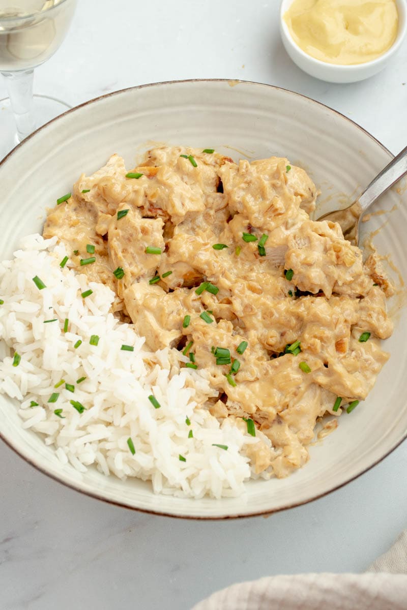 Creamy mustard chicken on a plate with rice.