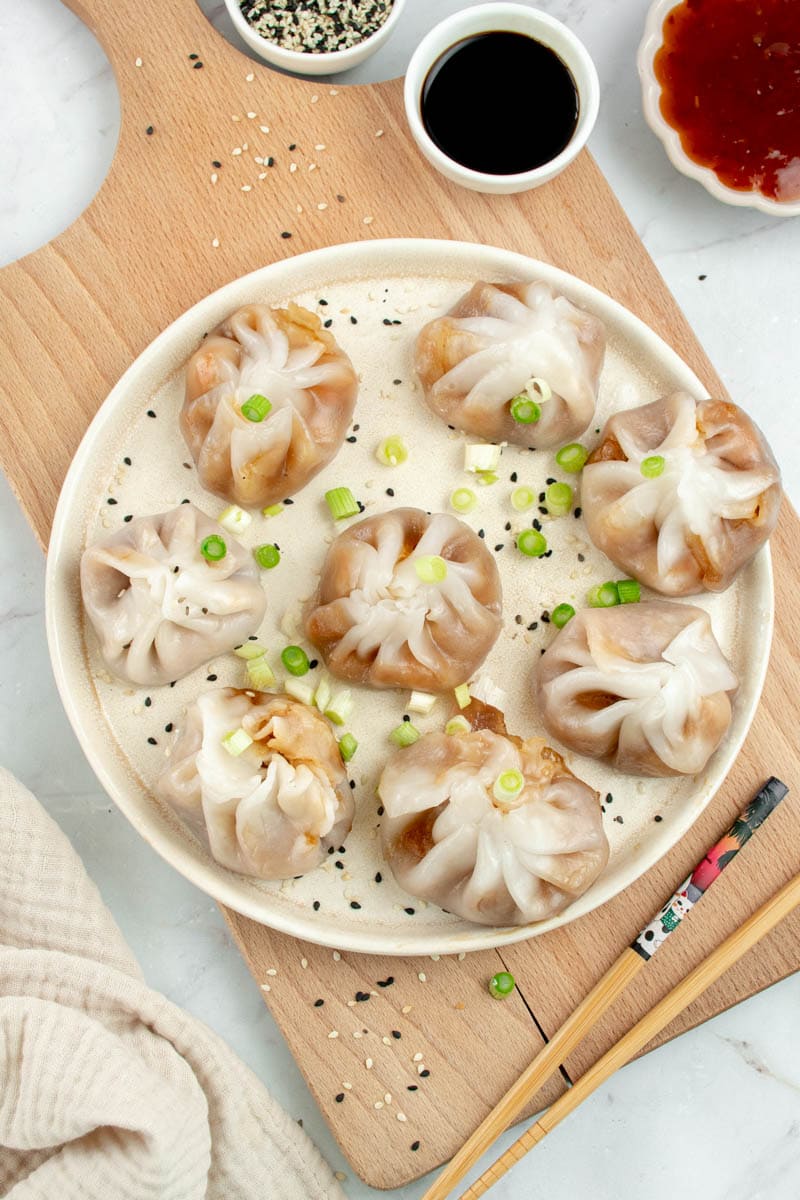 Dim Sum on a plate with a few slices of spring onion.