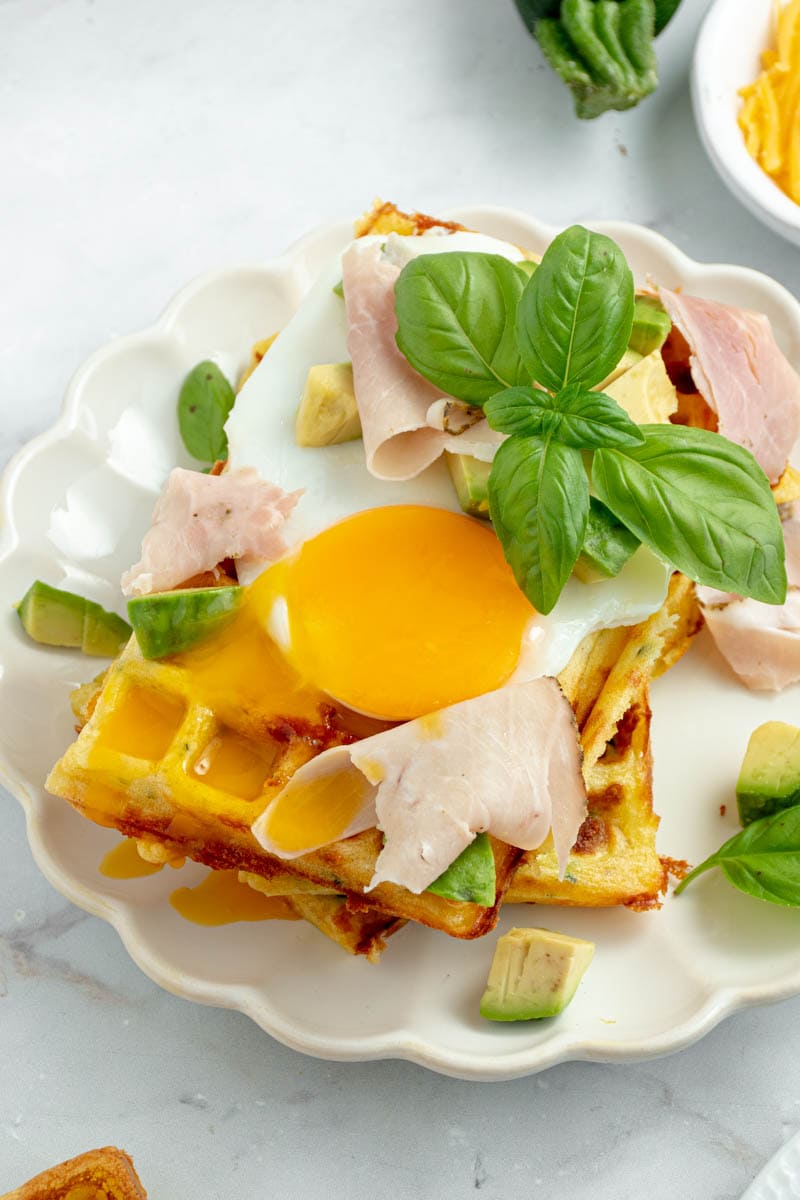 Zucchini and cheddar waffle with fried egg, basil and ham.