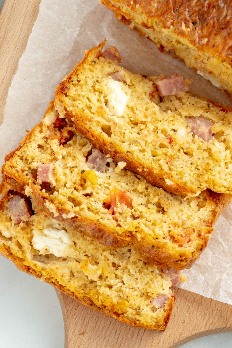 Sliced sun-dried tomato and feta cake on baking paper.