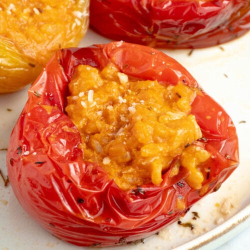 Poivrons farcis d'un risotto ultra crémeux à la tomate dans une assiette.