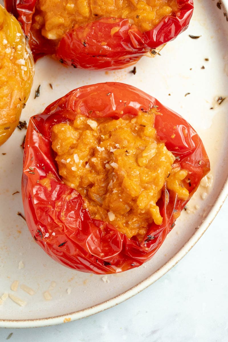 Poivrons farcis d'un risotto ultra crémeux à la tomate dans une assiette.