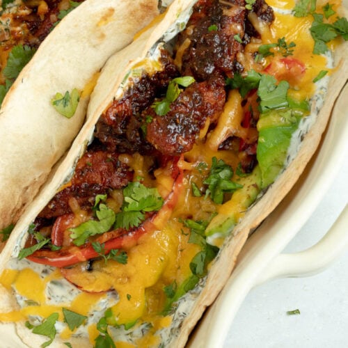 Tacos garni de poulet et sauce barbecue, cheddar et sauce au yaourt et aux herbes.