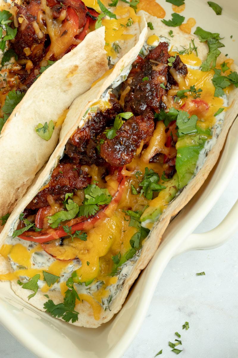Tacos topped with chicken and barbecue sauce, cheddar cheese and yogurt-herb sauce.