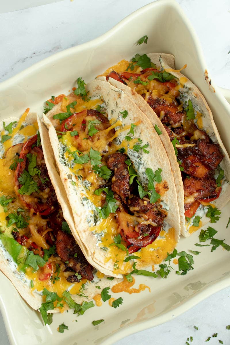 Tacos topped with chicken and barbecue sauce, cheddar cheese and yogurt-herb sauce.