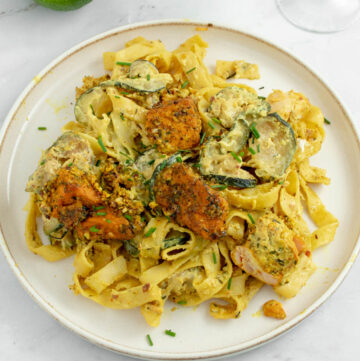 Tagliatelles au saumon dans un plat accompagné d'un verre de vin et d'un citron.