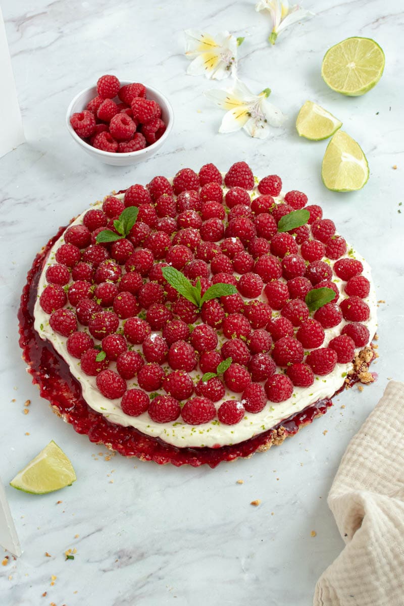 No-bake tart with whipped cream, fresh raspberries and lime zest.