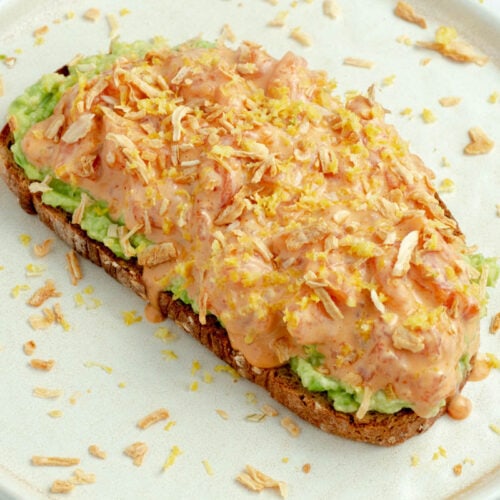 Toast avocat, saumon et spicy mayo dans une assiette.