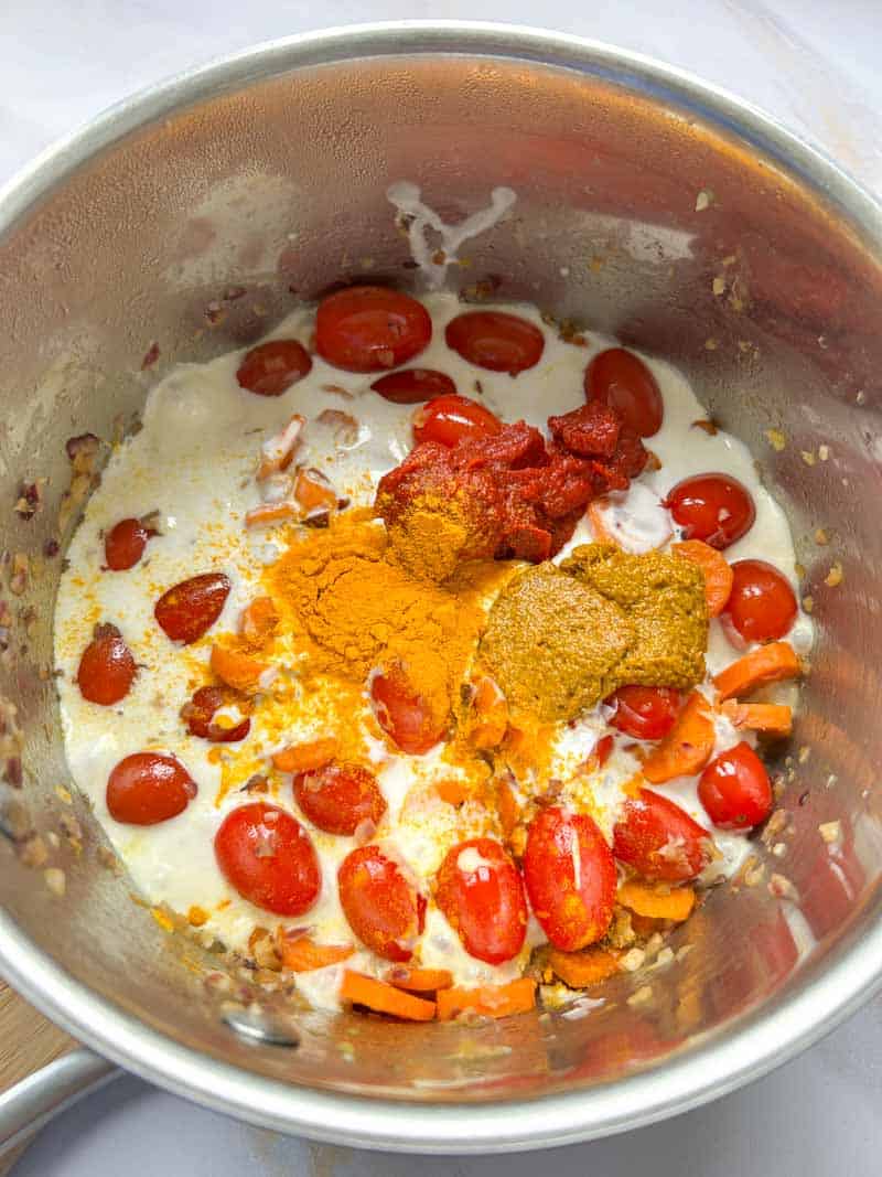 Ajout de la crème de coco, la pâte de curry, le curcuma et le concentré de tomate.