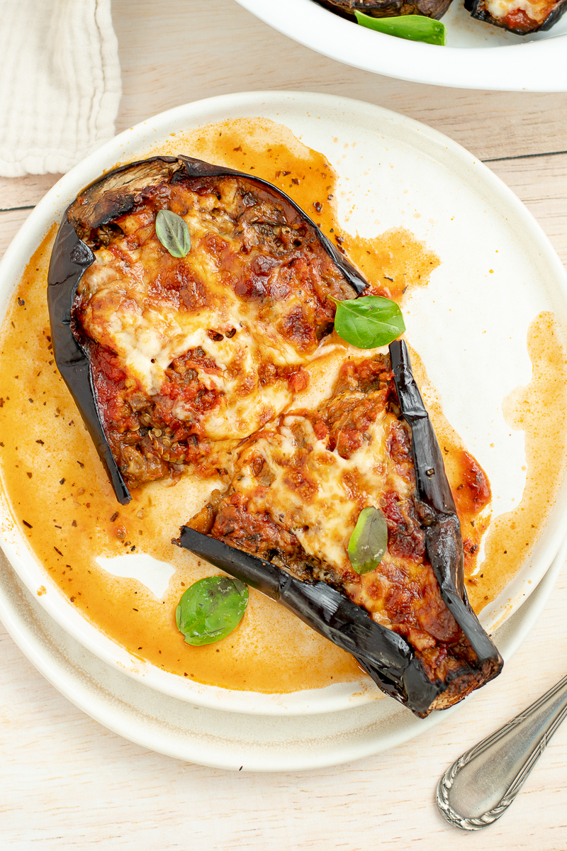 Half eggplant in a white plate with sauce.