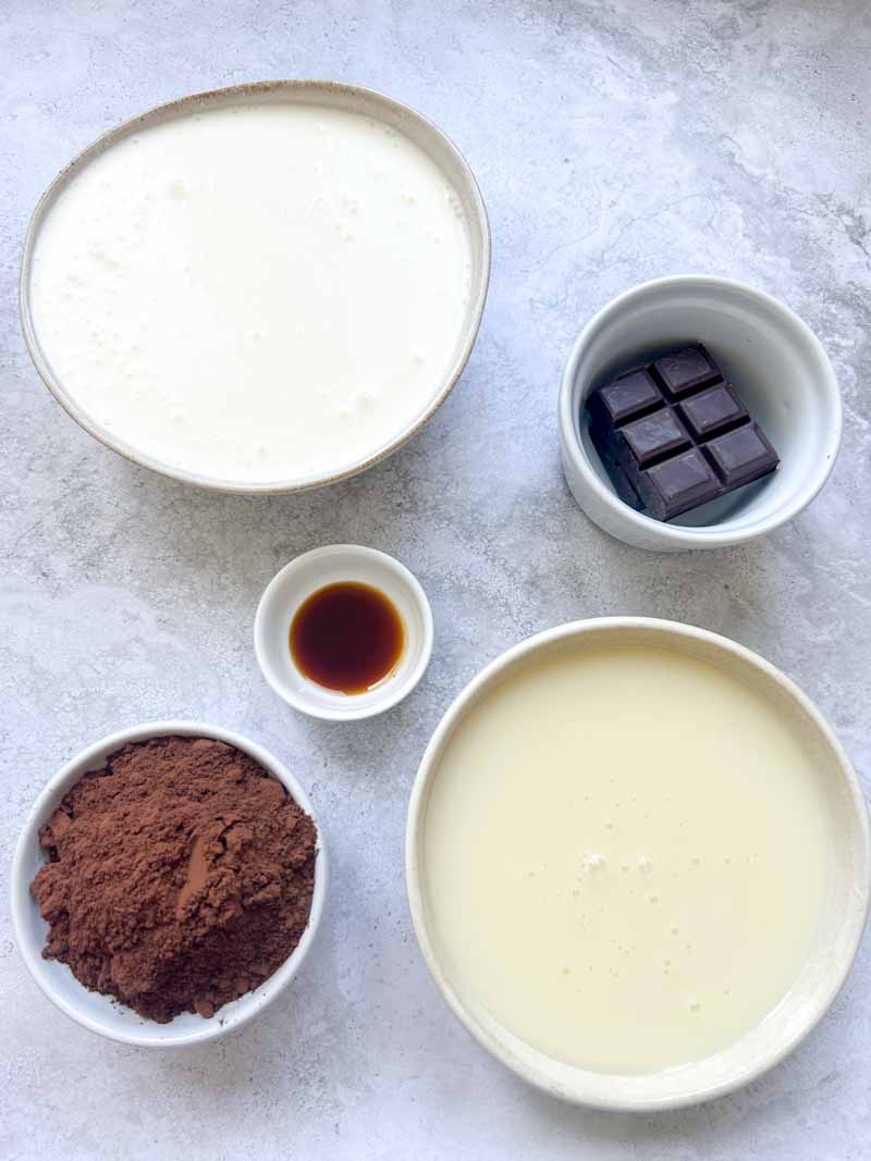 Ingredients of no-churn chocolate ice cream in bowls.