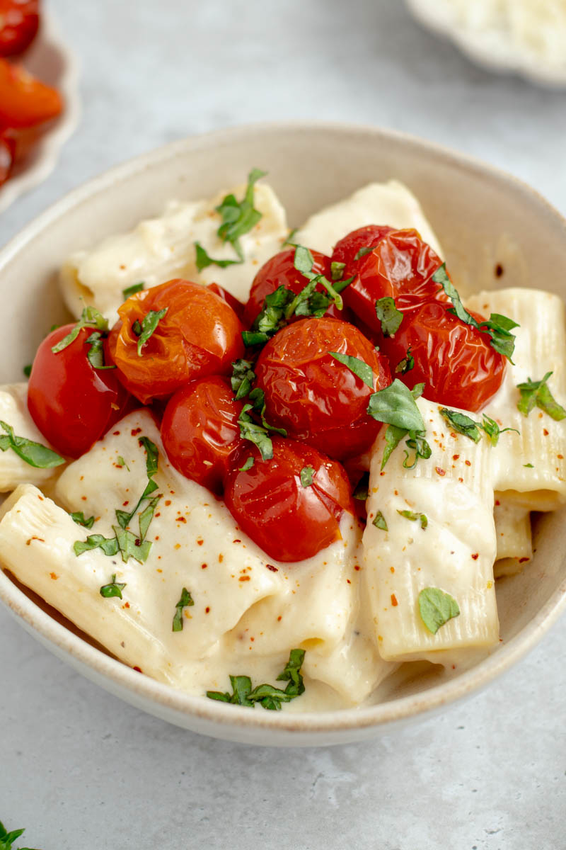 Creamy garlic confit pasta with cherry tomatoes in a bowl.
