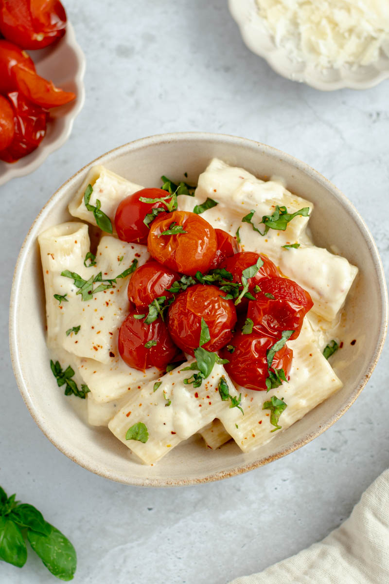 Creamy garlic confit pasta with cherry tomatoes in a bowl.