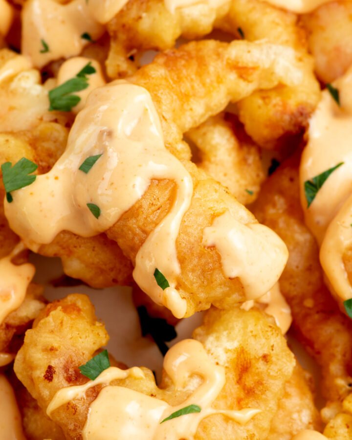 Zoom on a crispy fried shrimp with boom boom sauce.