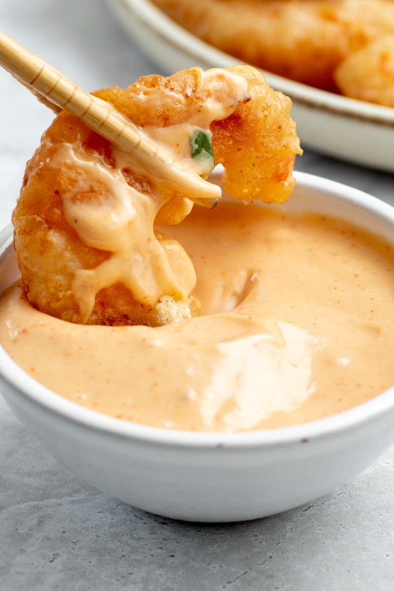 Crispy fried shrimp dipped in boom boom sauce bowl.