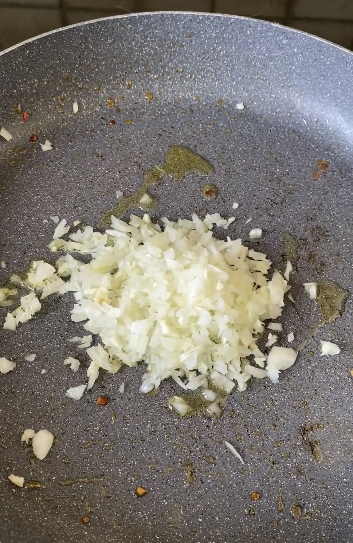 Finely chopped garlic and onion, cooking in a frying pan.