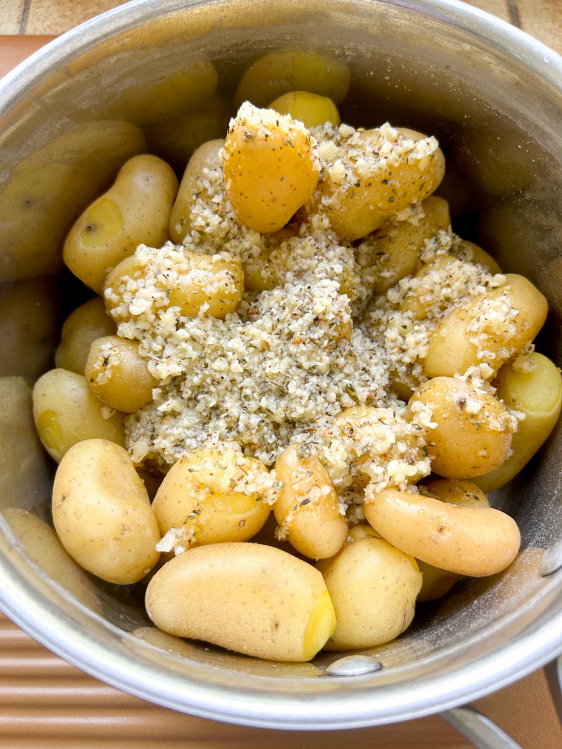 Pommes de terre dans un bol recouvertes avec le mélange de beurre