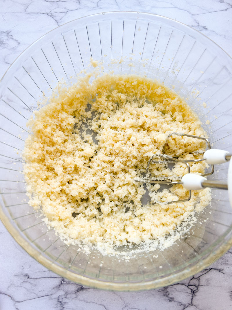 Les sucres et le beurre mélangés dans un bol transparent.