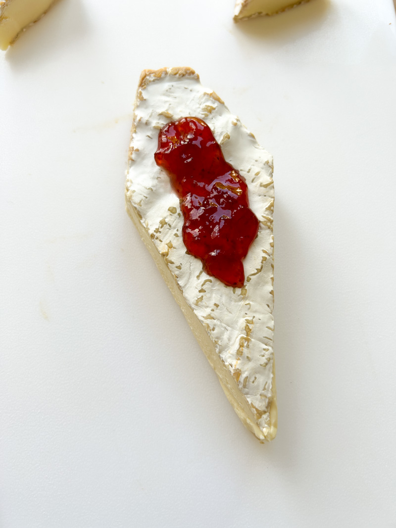 Brie cheese in a form of coffin with strawberry jam on it, to look like blood.
