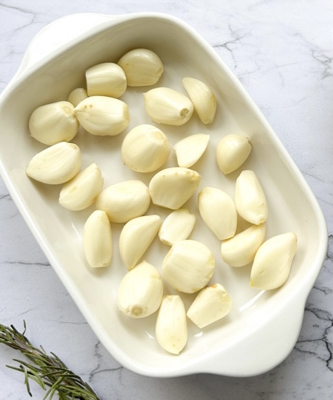 Fresh cloves of garlic in an oven-safe dish.