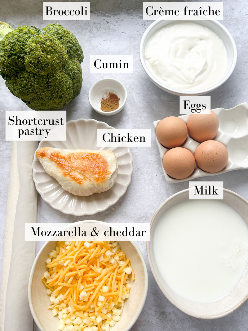 Ingredients of chicken broccoli quiche in white and beige bowls.