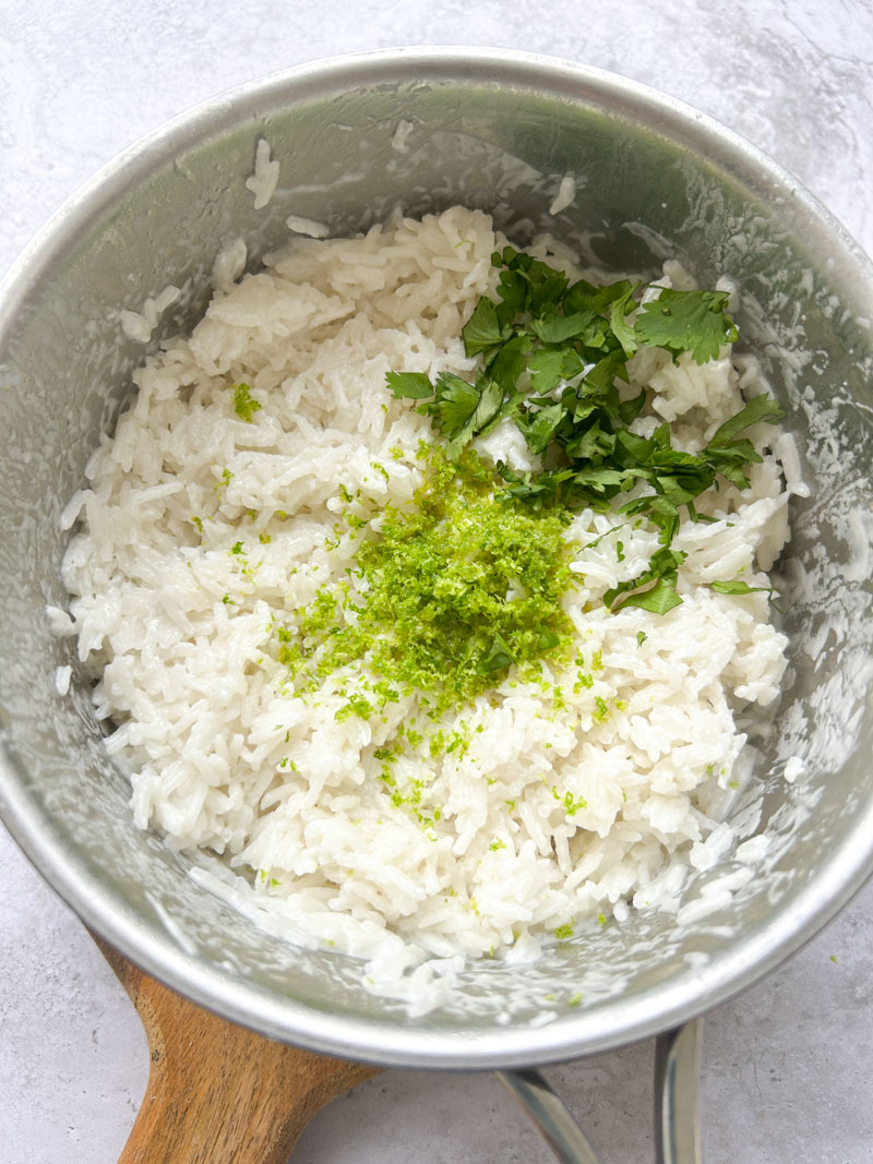 Zestes de citron vert, jus de citron vert et coriandre fraîche ajoutés au riz dans la casserole.