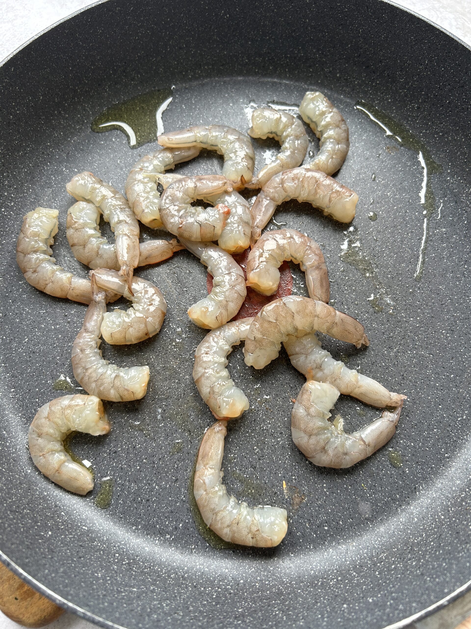 Crevettes crues dans une poêle avec de l'huile d'olive.