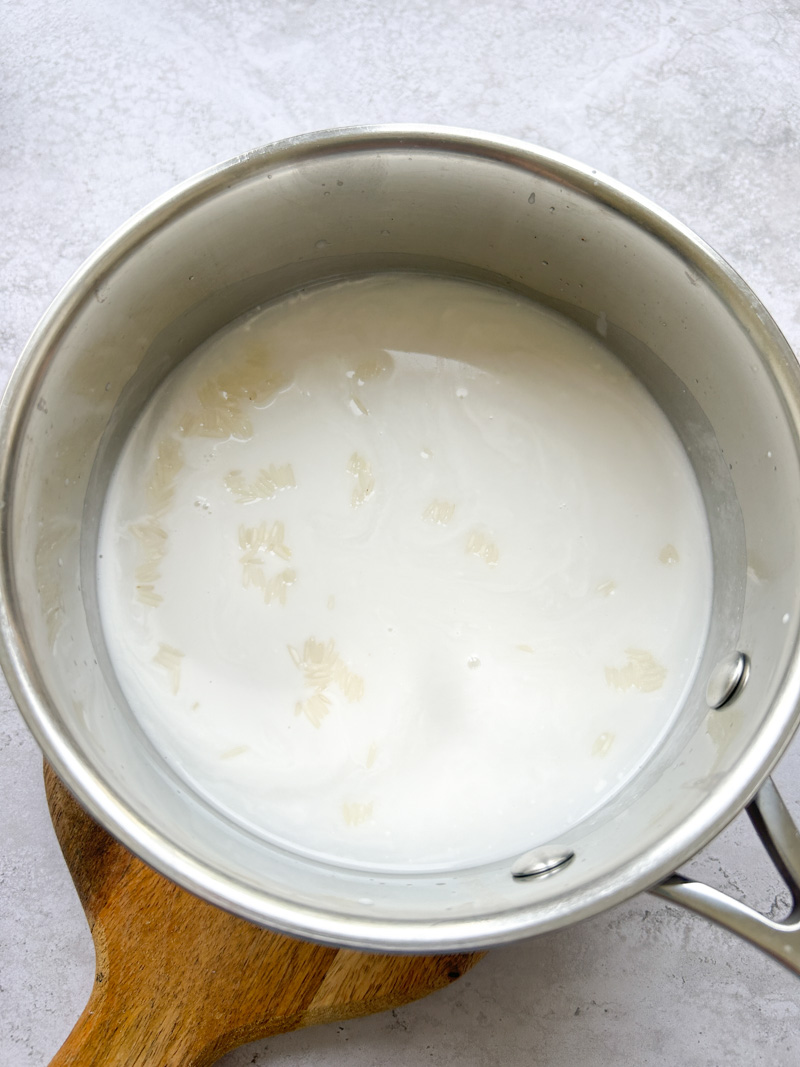 Riz dans une casserole avec le lait de coco et l'eau.