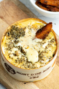 Baked Vacherin Mont d'Or with creamy, runny cheese and spicy potatoes.