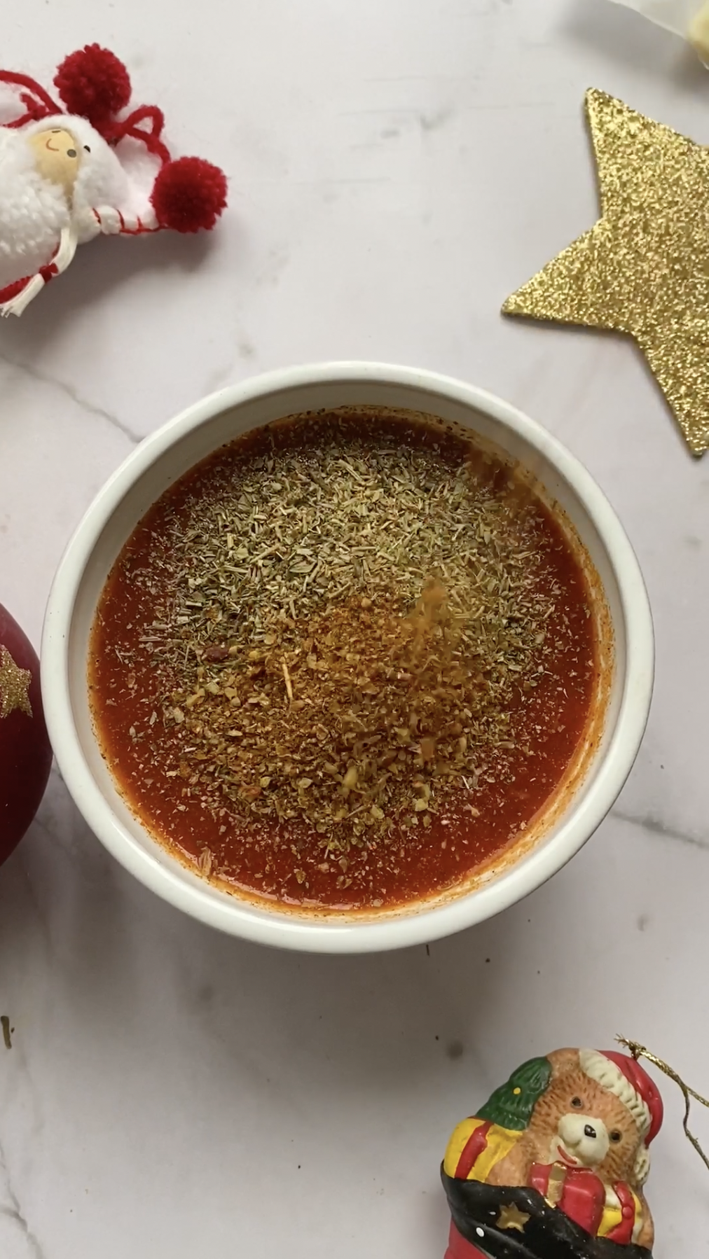 Italian seasoning added to the bowl of tomato sauce.