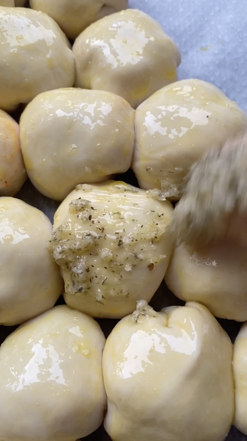 Butter mixture brushed on pizza balls.