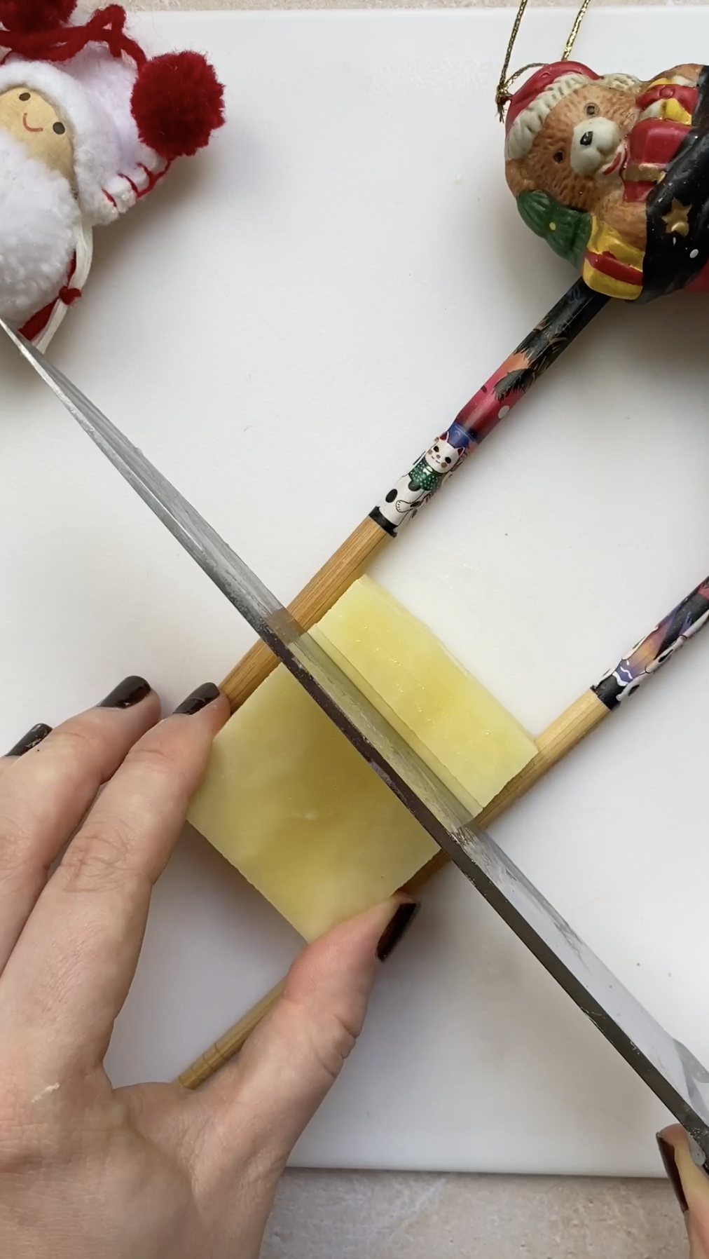 A hand holding a knife, cutting a potato horizontally.